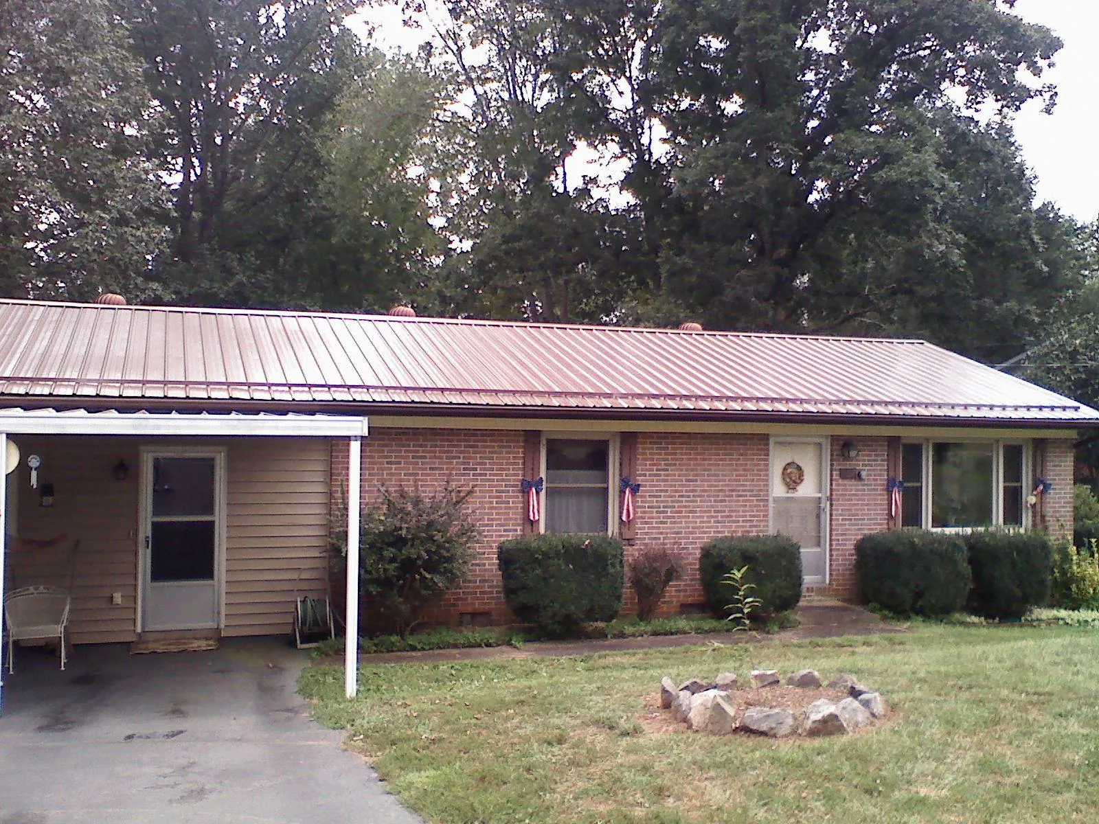 Bronze metal roof and carport on a brick ranch home — Roof Repair work by our crew in Oak Hill