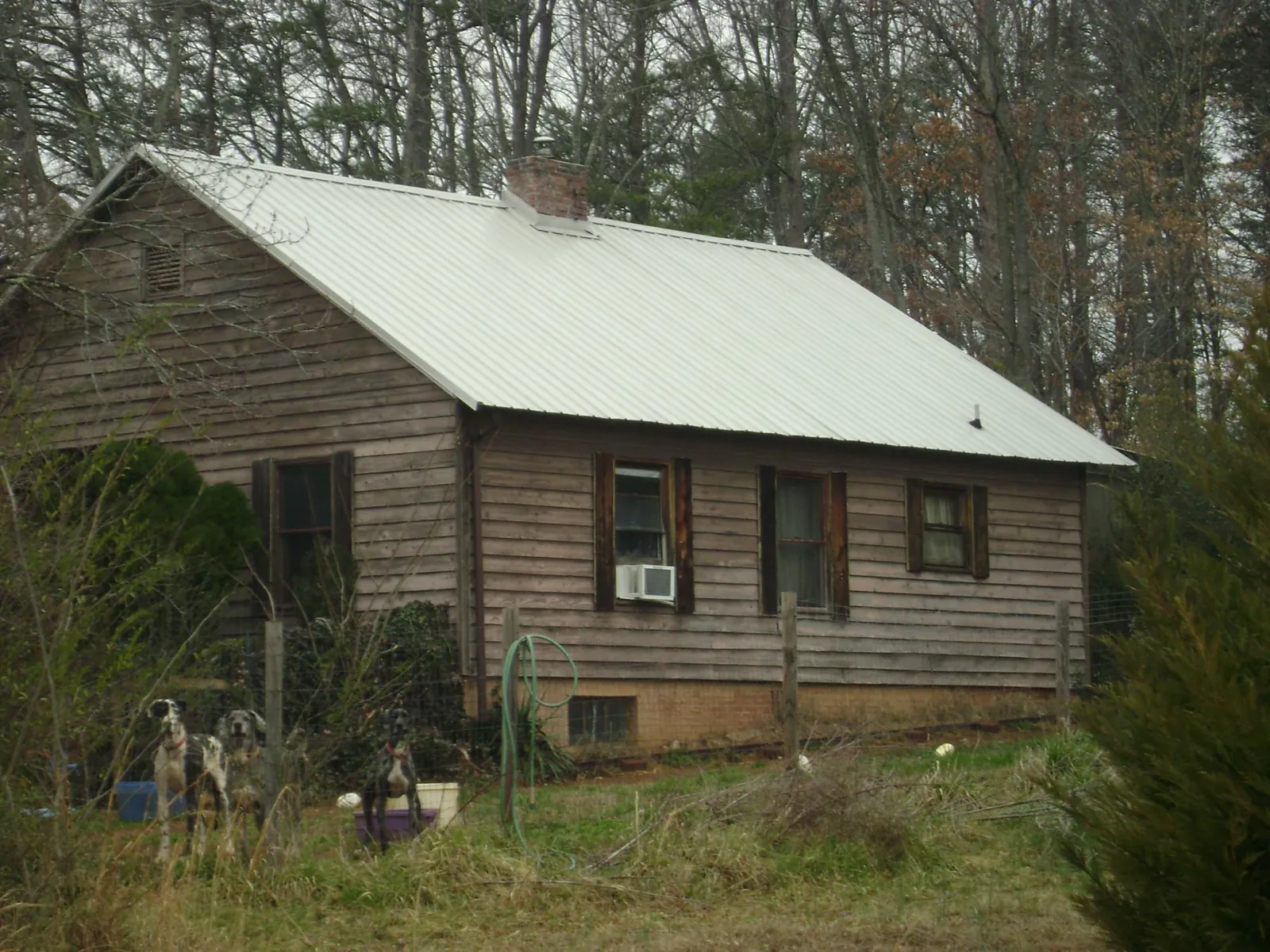 White metal roof on an old wood sided farmhouse, from a Metal Roof Installation job in Oak Hill